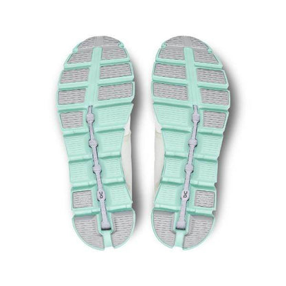 מבט מלמטה של On Cloud 5 59.98369 נעלי ספורט Creek M מאת On Cloud, מציגות סוליות מפולחות בצבע צהבהב ואפור עם חריץ מרכזי ודפוס דריכה מרקם.