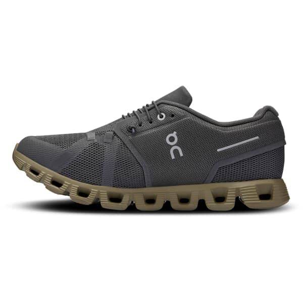 מבט מהצד של On Cloud 5 Eclipse/Grove 59.97769, נעל אתלטית אפורה כהה של On Cloud עם חלק עליון בעל מרקם. הסוליה כוללת תרמילי ריפוד, ויש פס מחזיר אור על העקב. הנעל מציגה גם את הלוגו "OC" בצד.